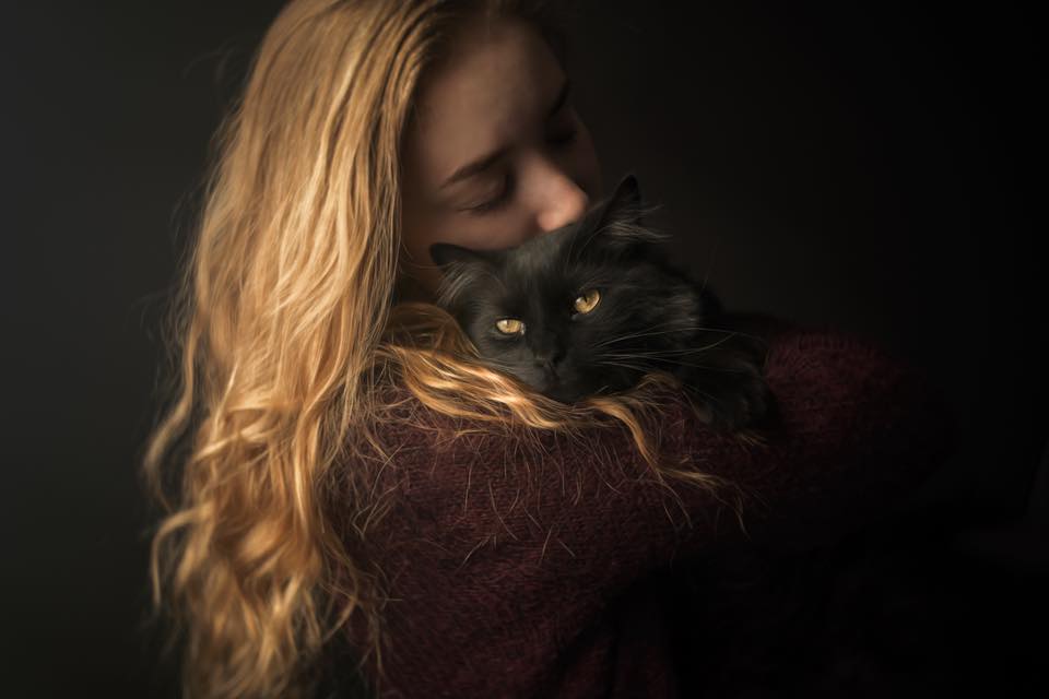 girl with blonde hair holding black cat with yellow eyes cuddling caroline jensen Lensbaby featured photos of the week