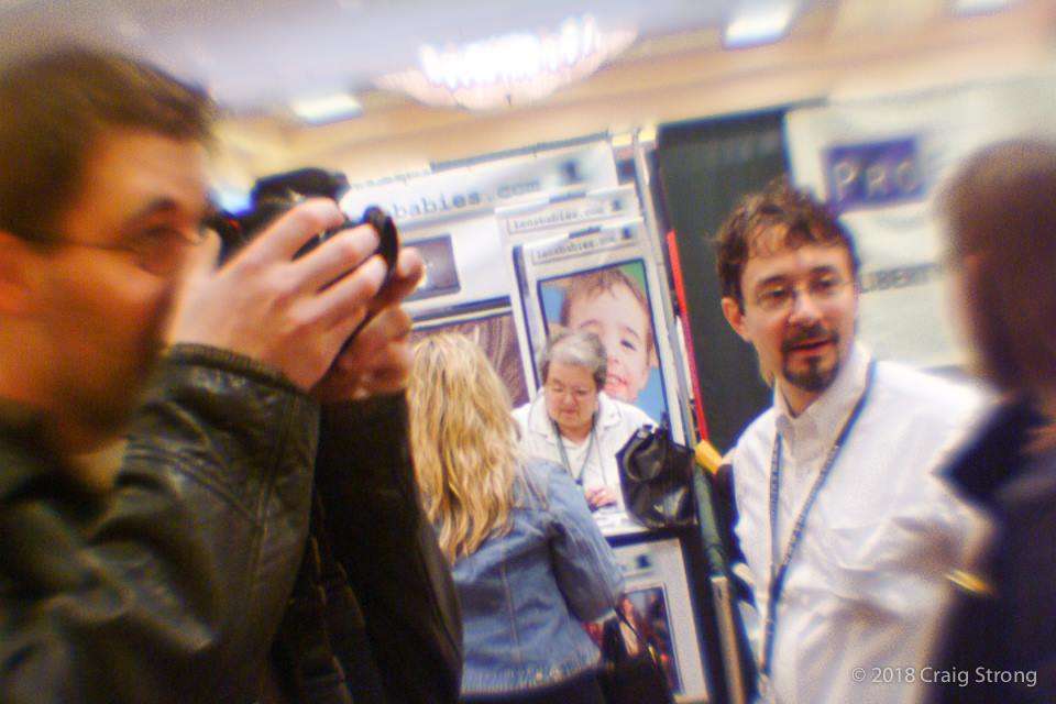 camera tradeshow people taking photos selective focus Lensbaby history craig strong WPPI