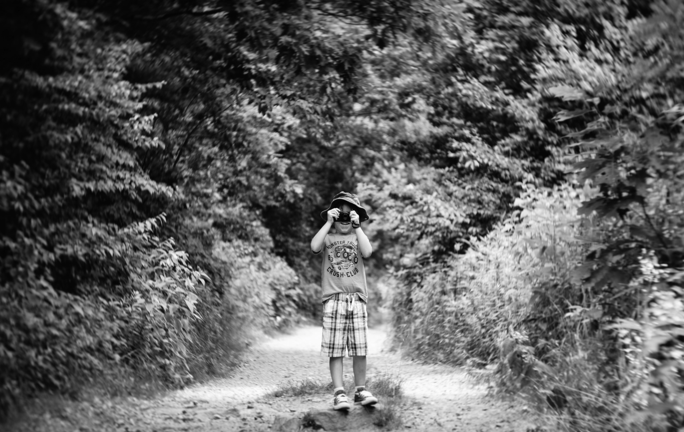 kid standing on a path in the forest taking a picture black and white parker pfister twist 60