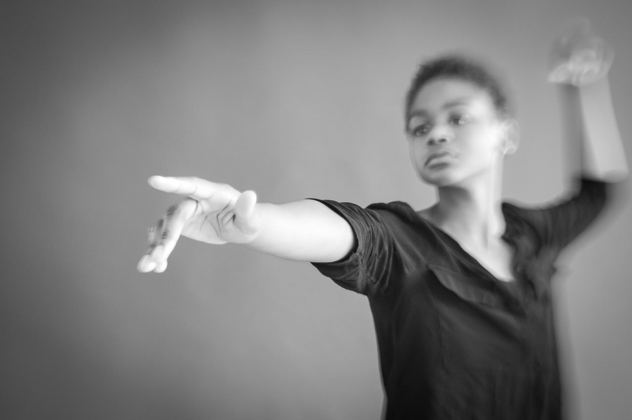 dancer in black tshirt strikes a dramatic pointing pose black and white selective focus photography journey story susan currie