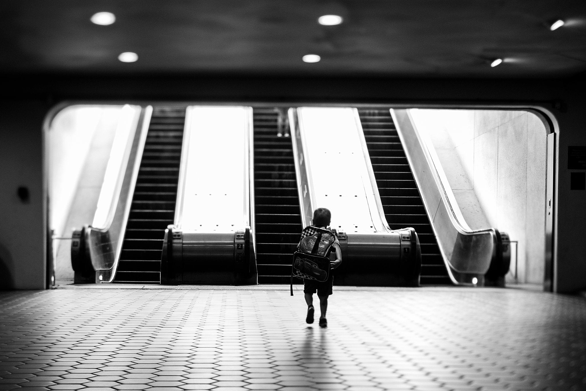 boy with backpack walking through Washington DC Metro approaching stairs Chelsea Lyn Lensbaby Challenge