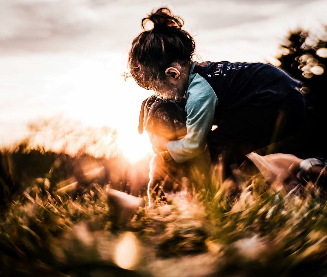 young girl with pug dog sunset backpack hug grass light flare twist Lensbaby featured photos